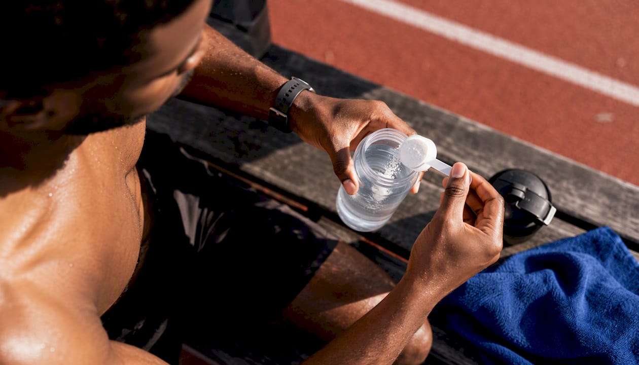 Black athlete mixing electrolytes before training