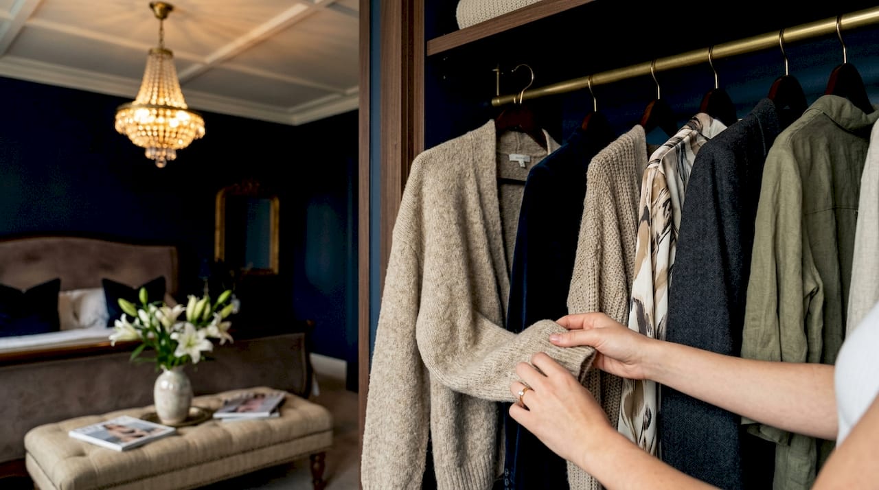 Hands choosing jacket in organized closet