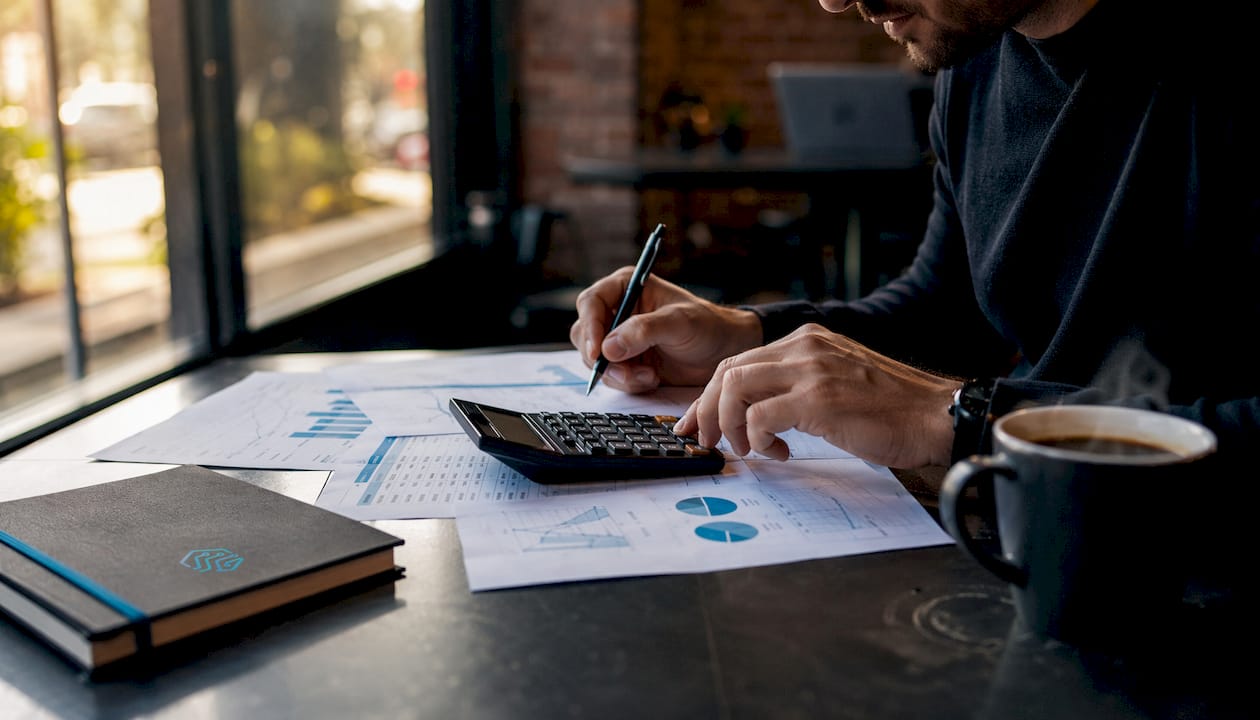 Manos revisando documentos para calcular el retorno de inversión de un software
