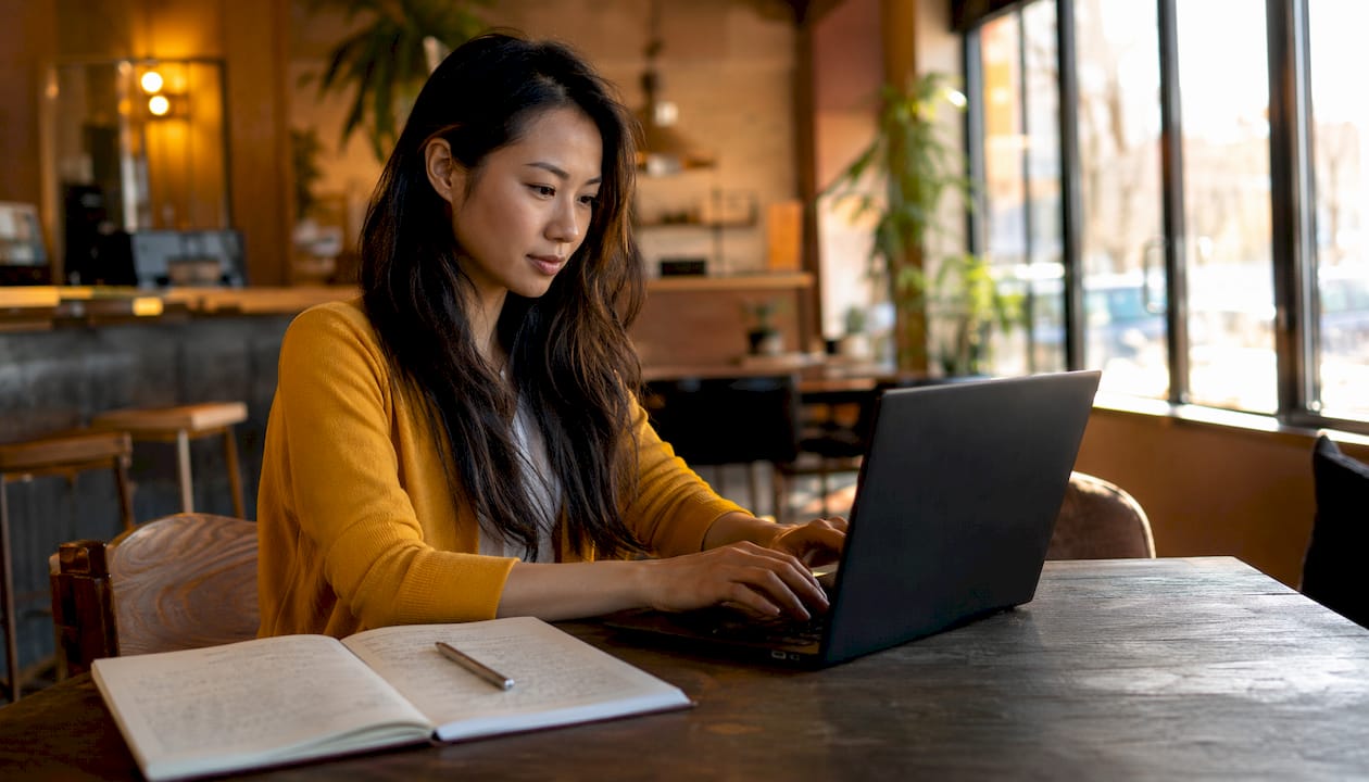 Les mains d’une femme en train de taper sur le clavier de son ordinateur portable