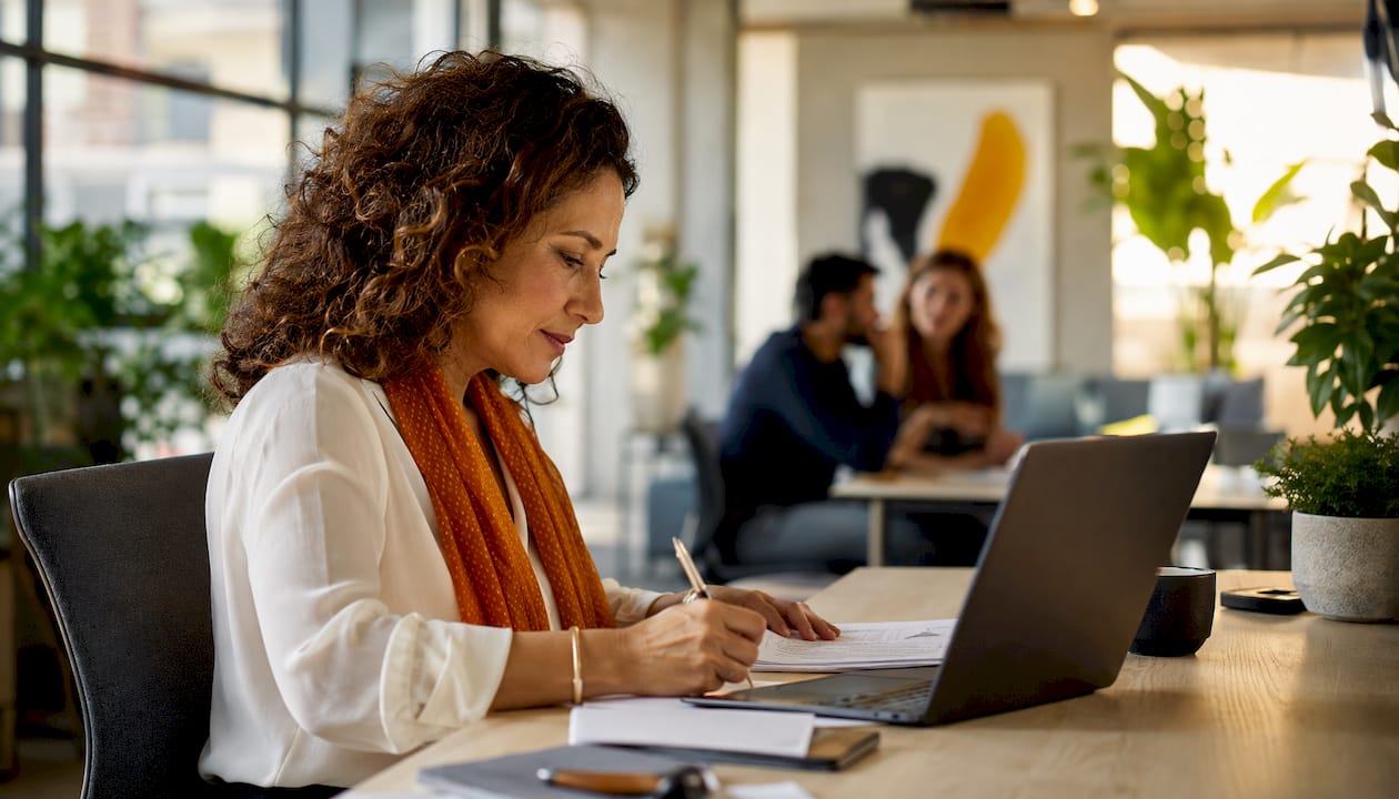 Une spécialiste en analyse financière en pleine étude de documents pour dégager les indicateurs essentiels.