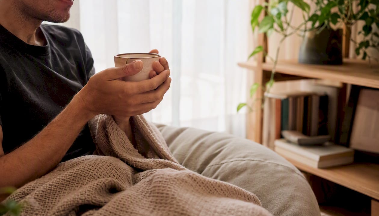 Une personne savoure le plaisir de verser une tisane chaude dans une ambiance paisible et apaisante.