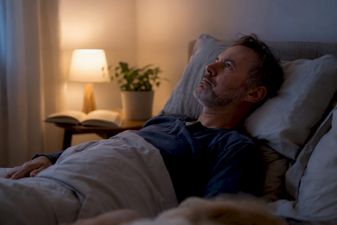 Un adulte en proie à ses pensées, incapable de trouver le sommeil, dans une chambre pourtant pleine de tranquillité.