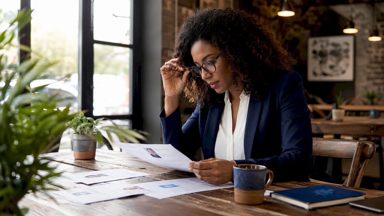 Hiring manager reviewing candidate resumes at table