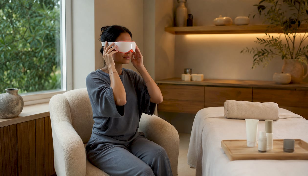 Hands setting up LED eye mask in clinic room