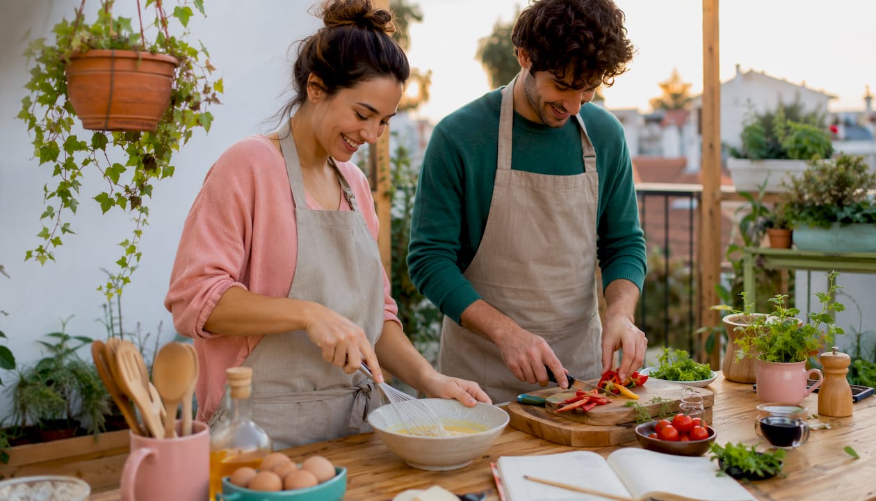 Una pareja disfruta de cocinar juntos en una cocina moderna.