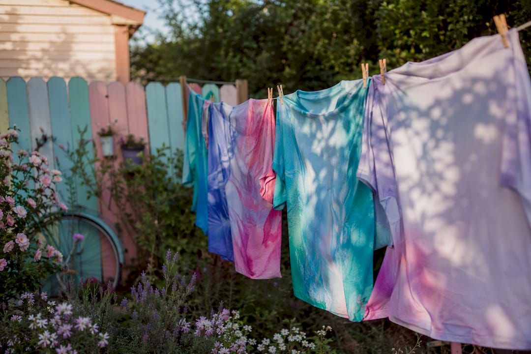 Camisetas sublimadas y coloridas secándose al aire libre