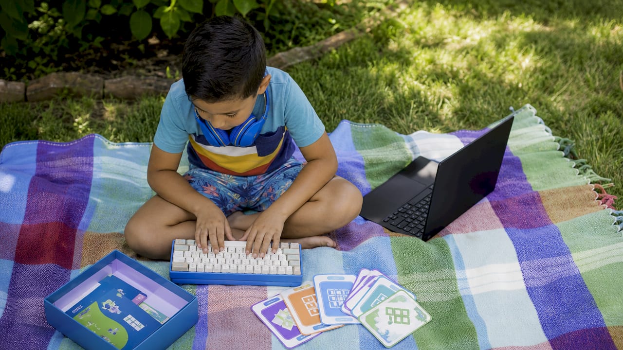 Boy engaging with open-source coding game setup