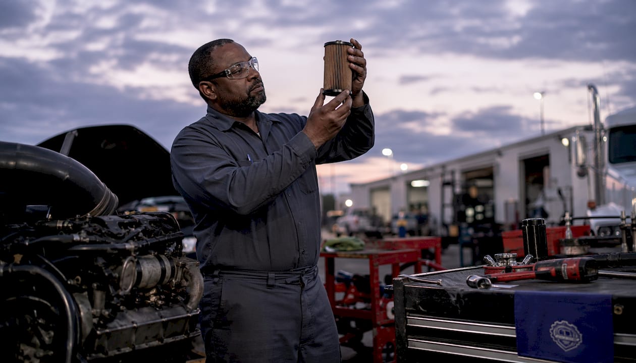 Technician inspecting diesel fuel filter for contamination