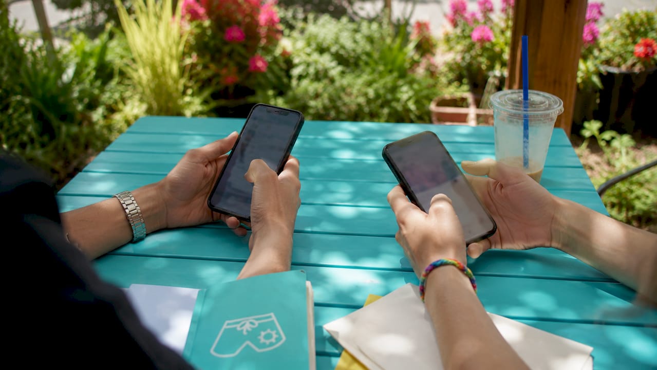 Hands using smartphones for timed guest communication