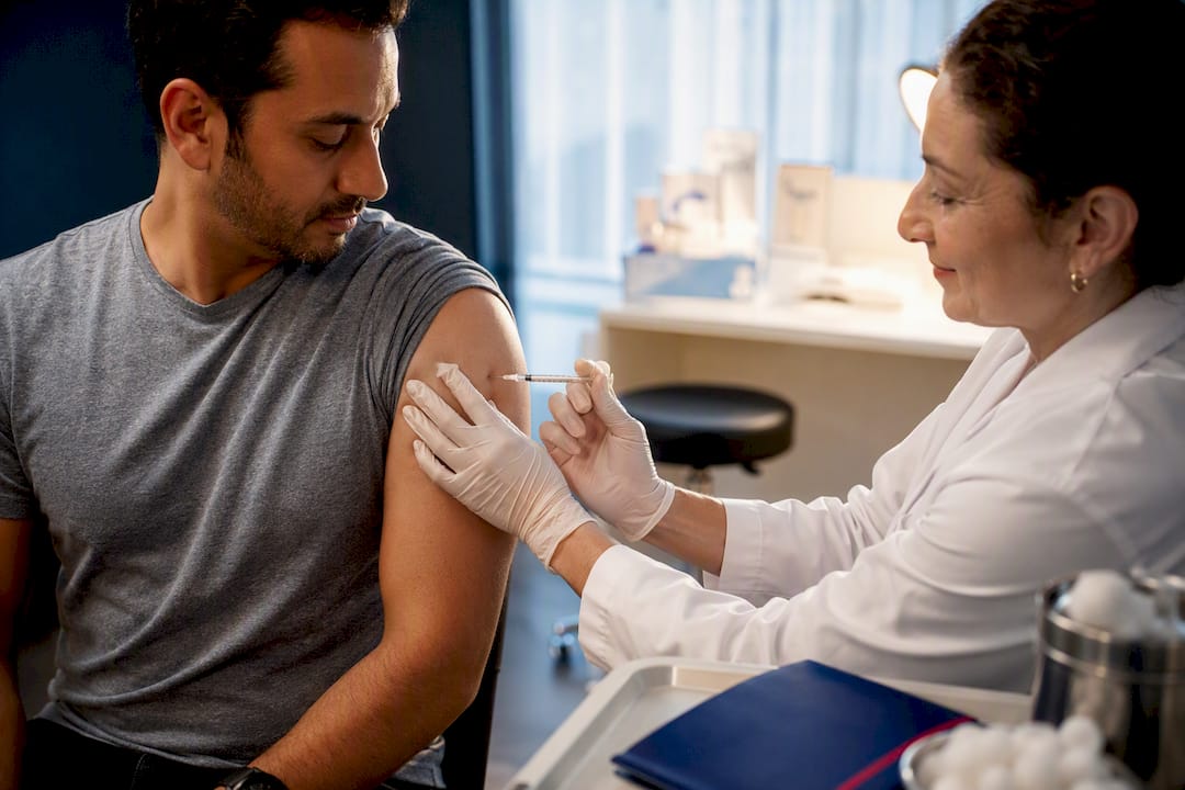 Applicant receiving vaccine during immigration exam