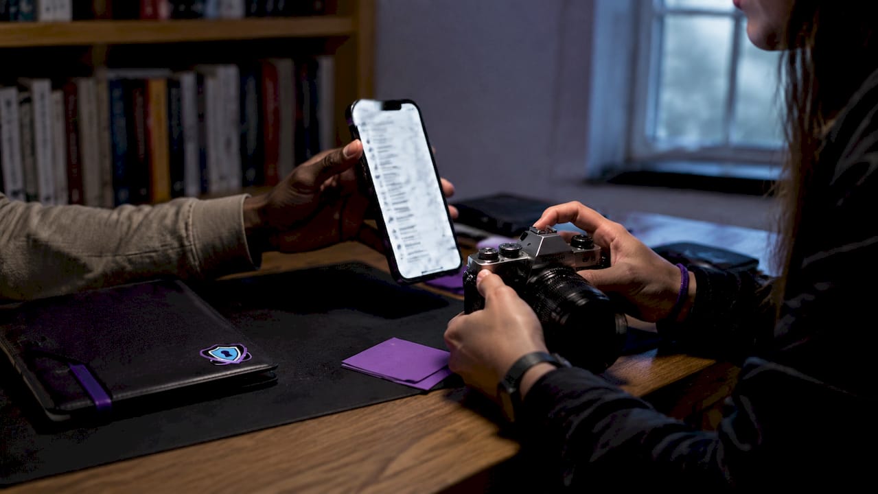 Hands photographing phone screen for breach evidence