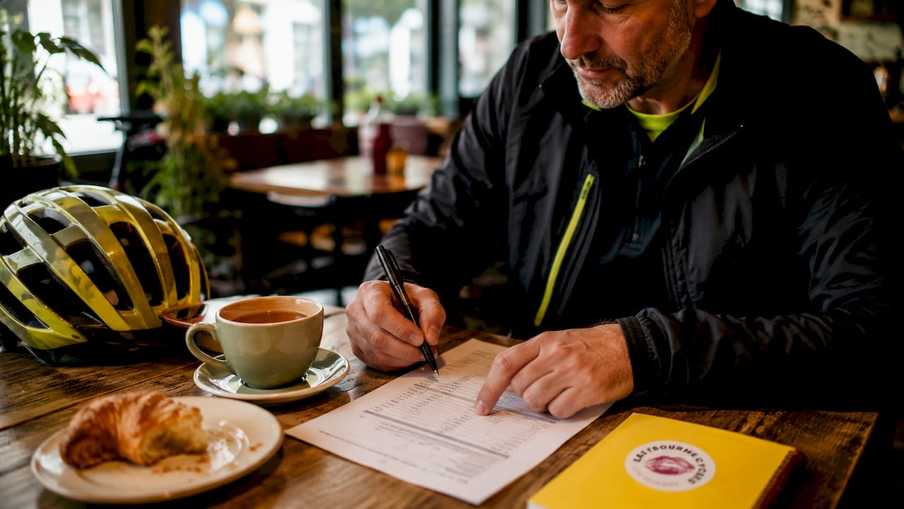 Man reviewing bike repair pricing checklist at home