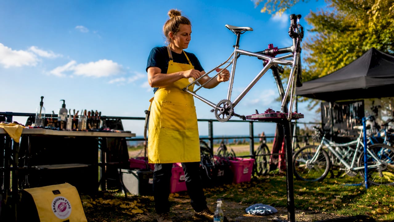 Bike mechanic inspecting a cleaned bike frame in workshop