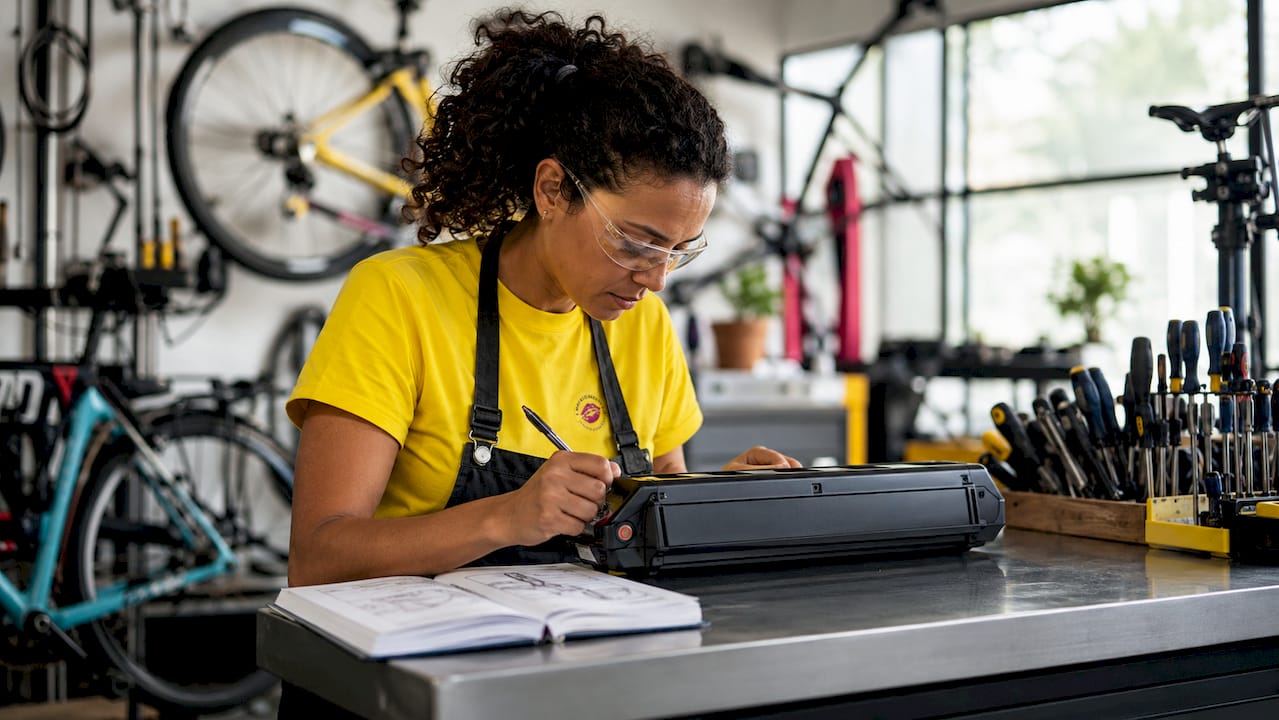 Technician inspecting e-bike battery in workshop