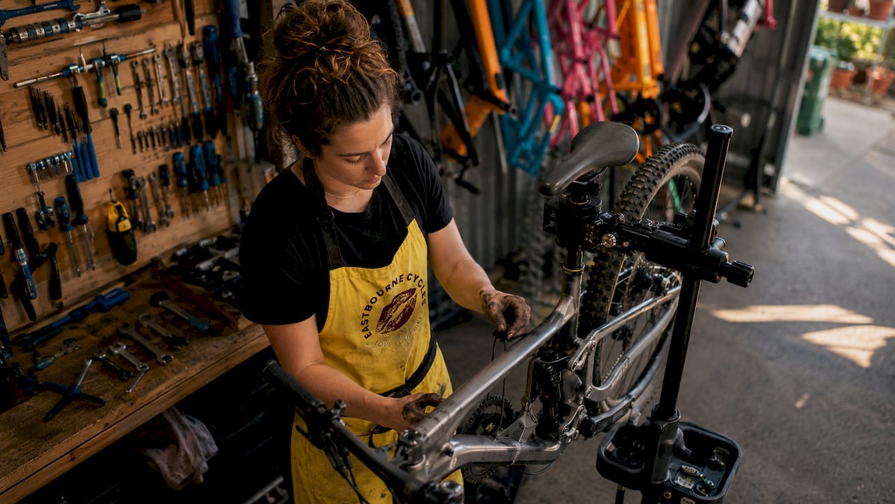 Mechanic inspecting mountain bike in workshop