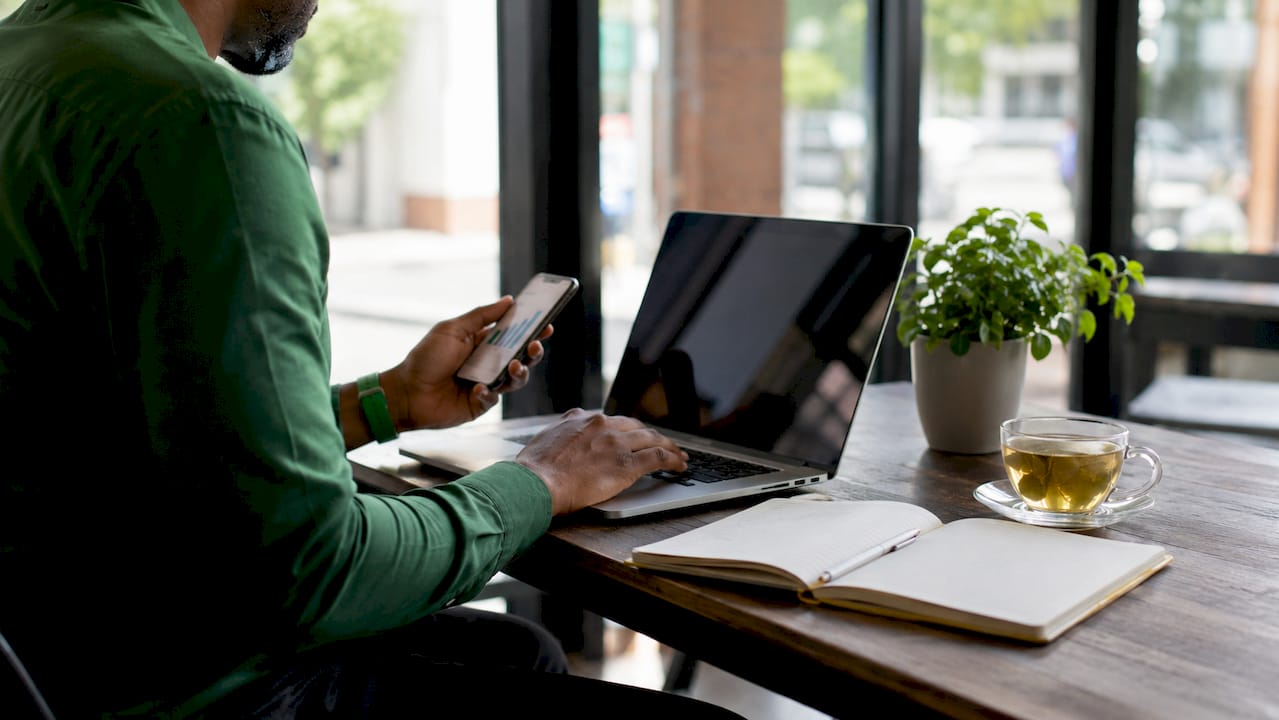 Hands using laptop and tablet reviewing tech stack