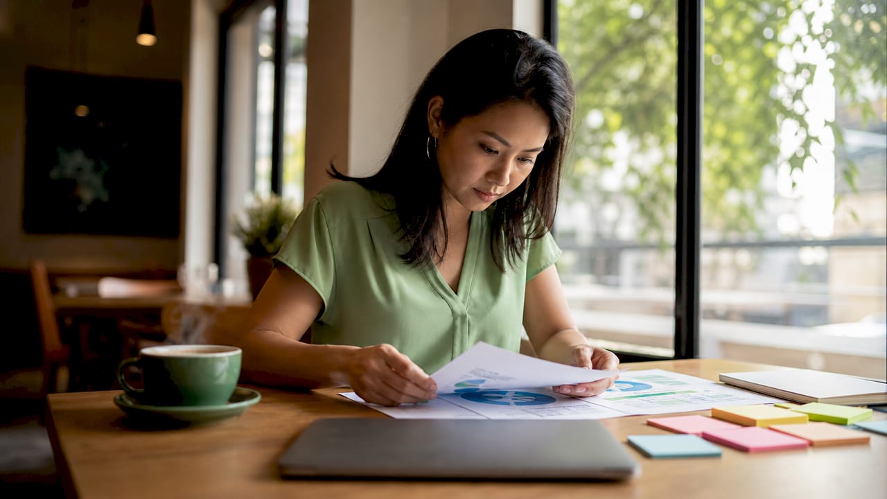 Woman reviewing marketing audit reports at desk