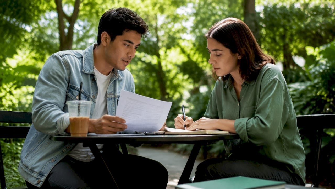 Couple discussing rent savings in café
