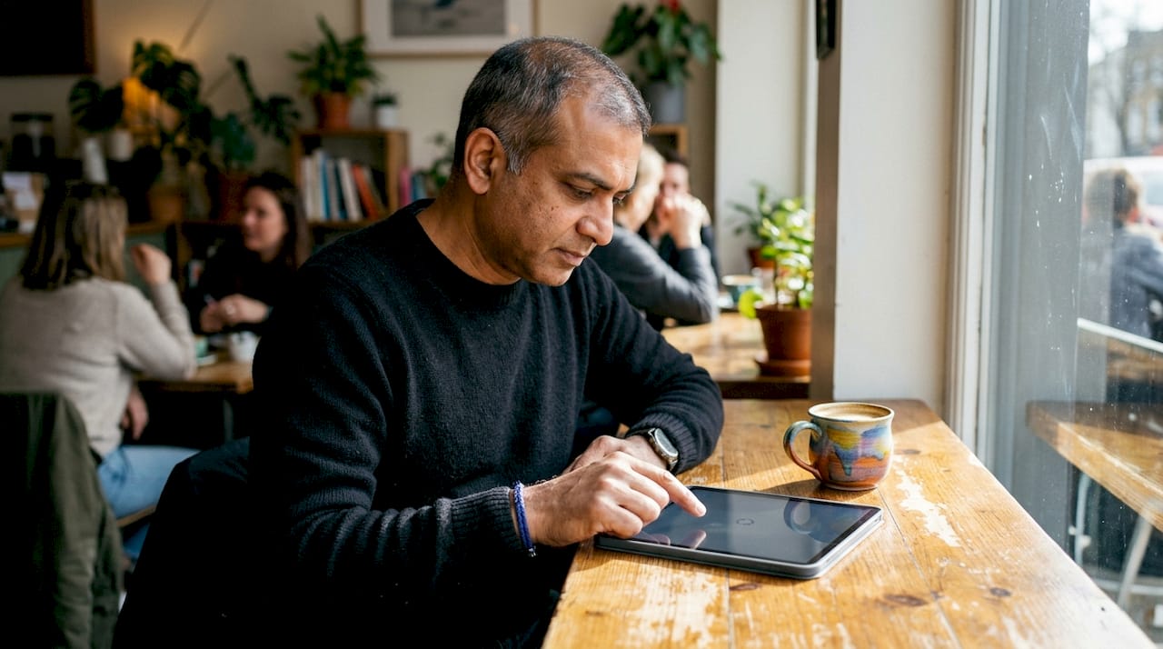 Man manually refreshing word puzzle on tablet