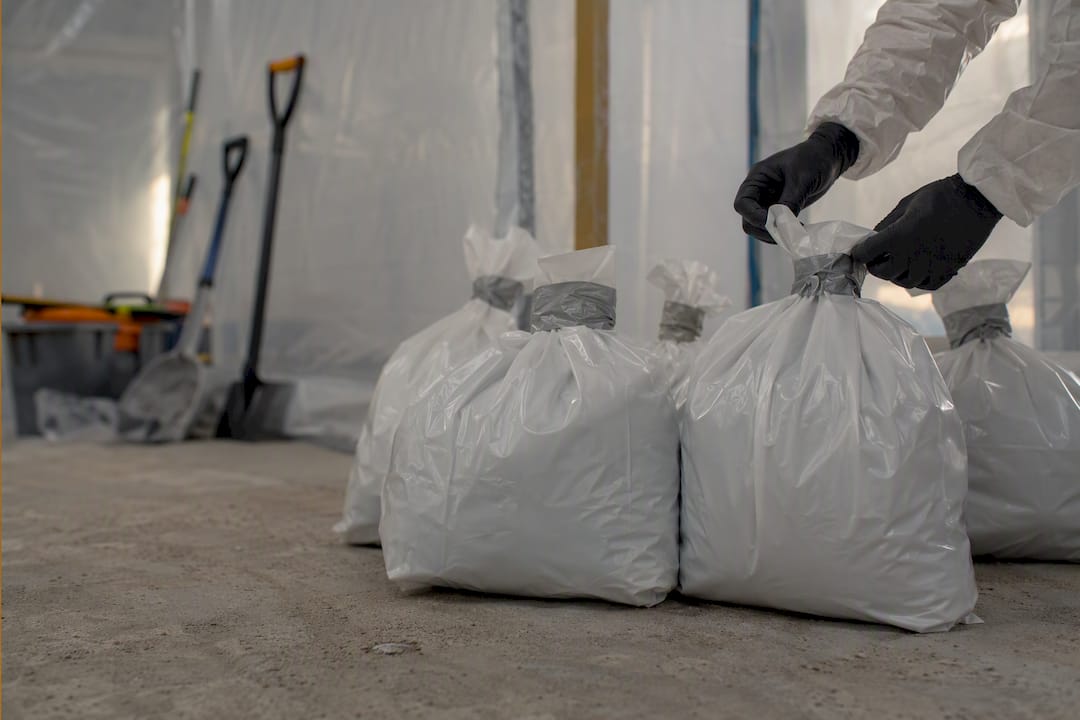 Sealed asbestos waste bags inside containment