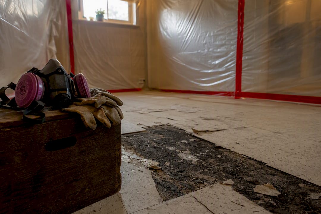 Sealed asbestos floor tile removal area in basement