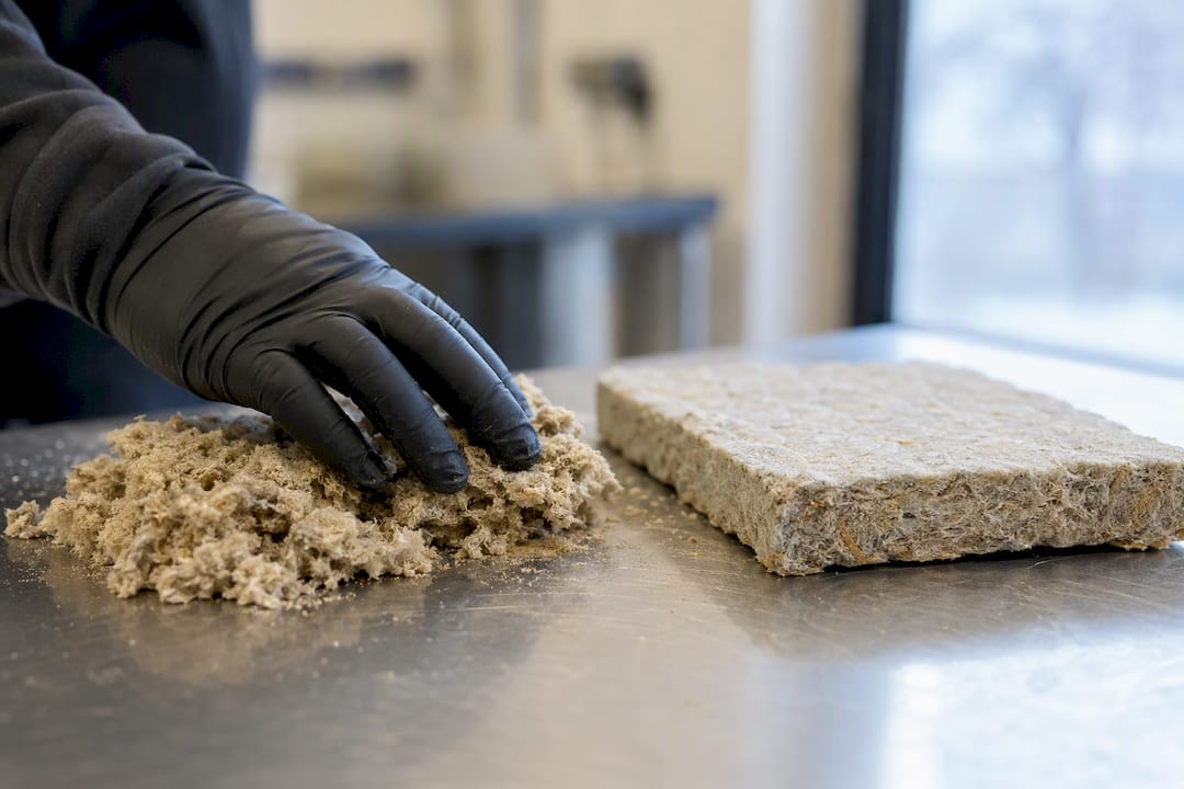 Gloved hand testing friable asbestos insulation