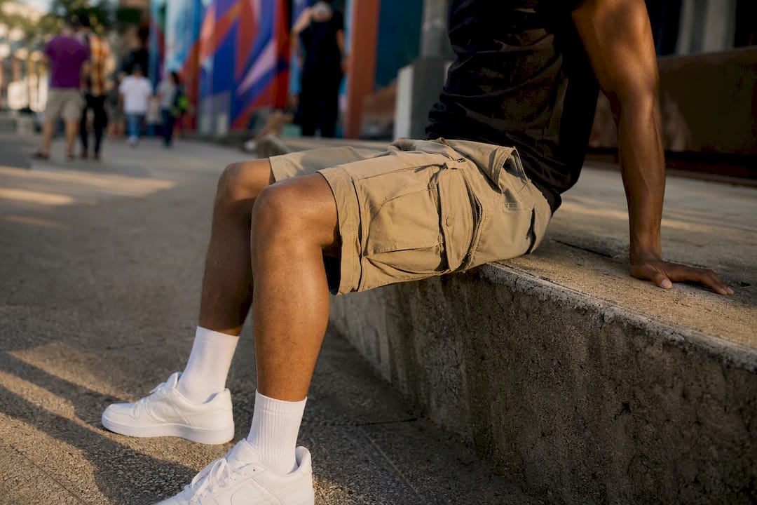 Man sitting showing cargo shorts fit and pocket behavior