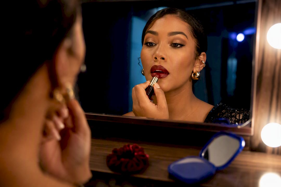 Attendee applying bold lip makeup backstage