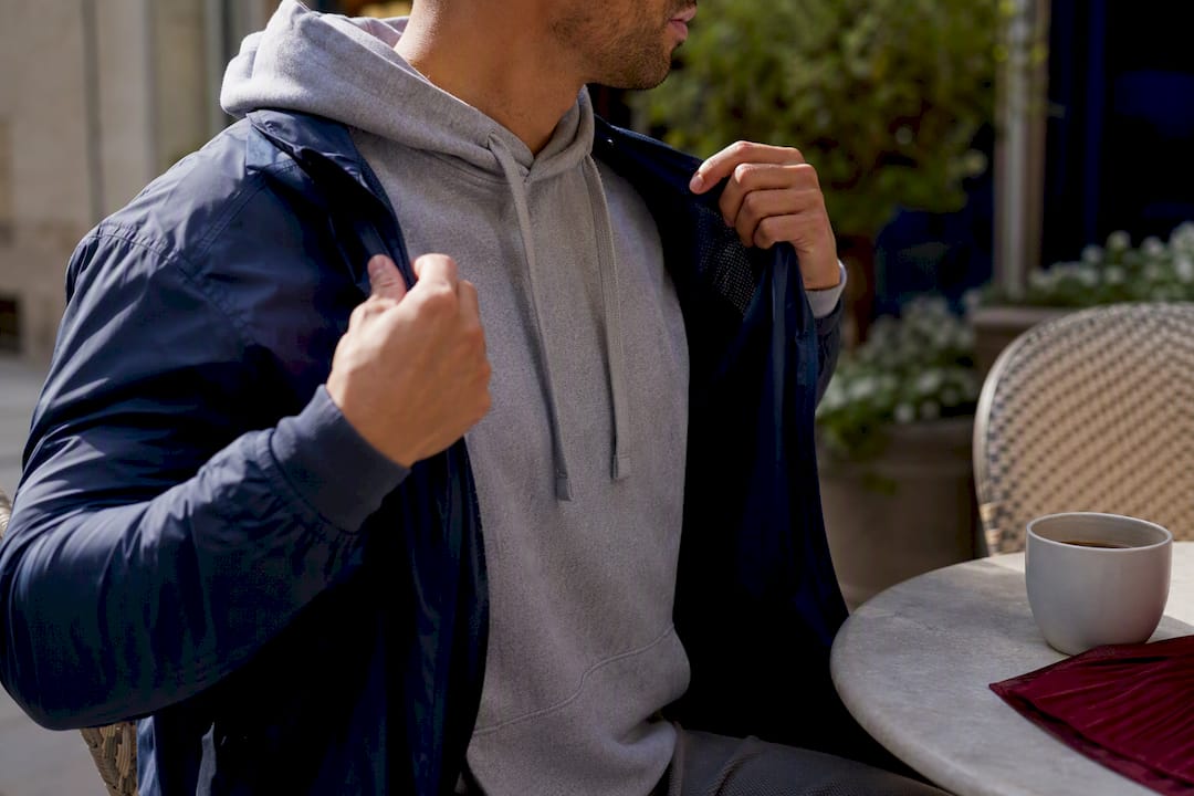 Hands removing a light jacket layer