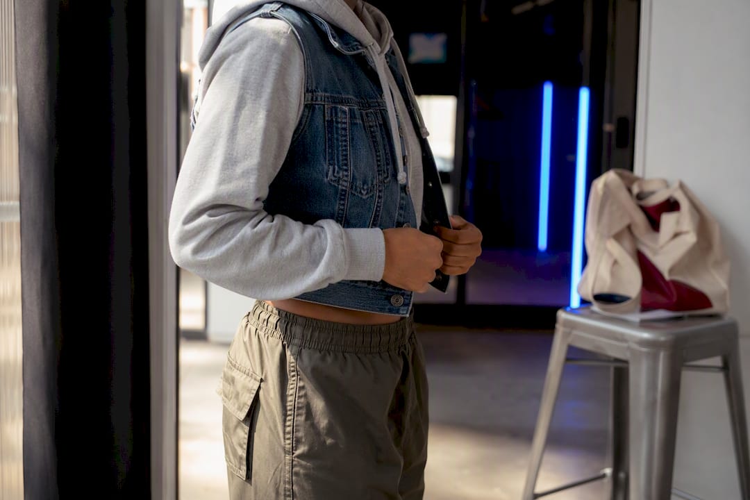 Layered cropped hoodie with denim vest and cargo pants
