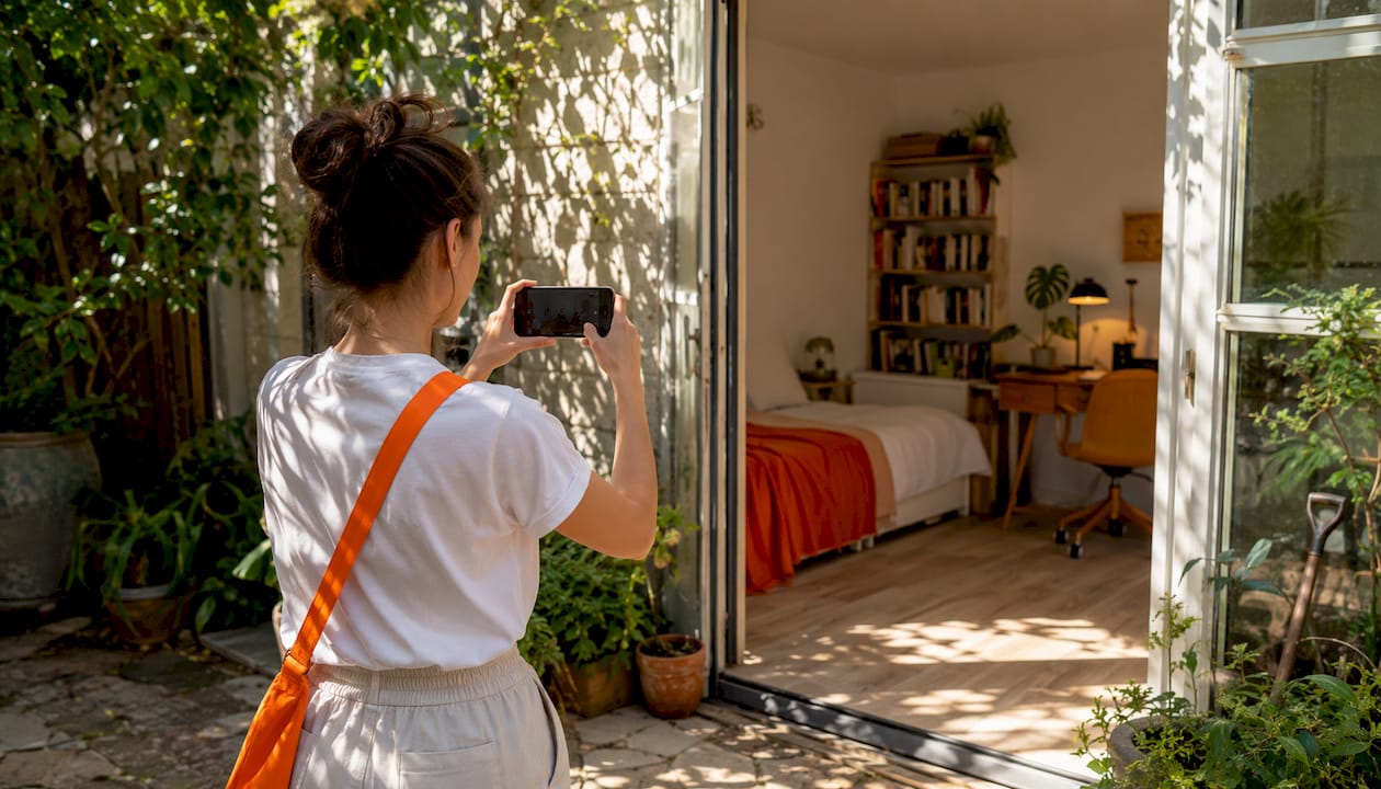 Young woman filming bedsit room for move quote