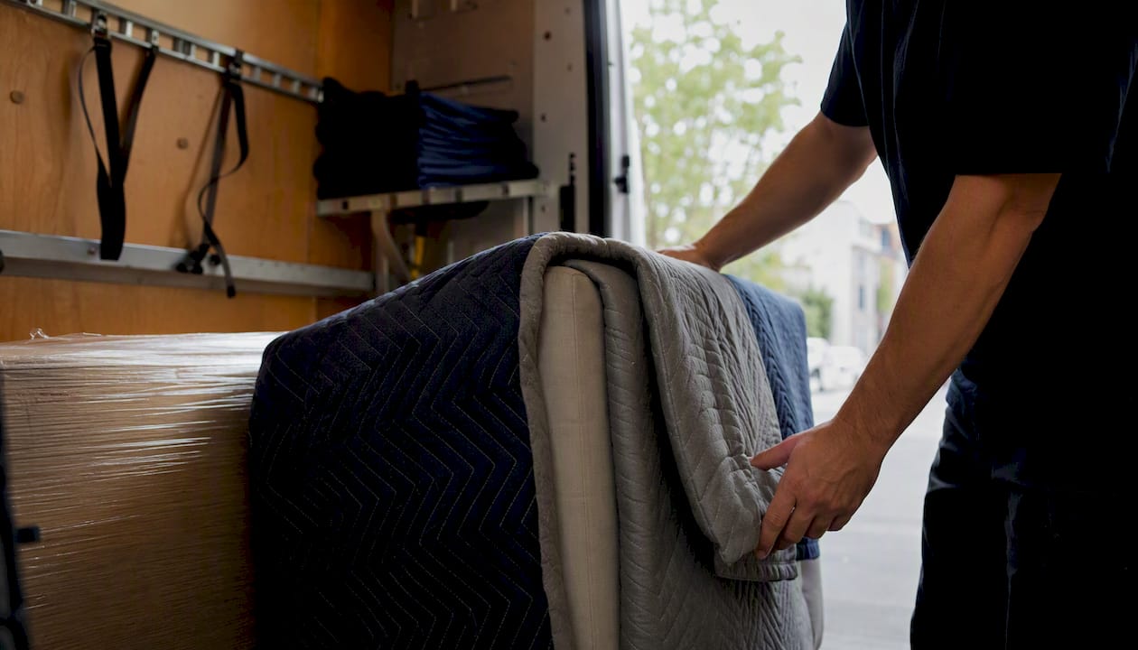 Removal worker wrapping furniture