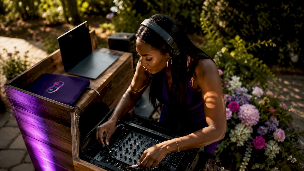 Female DJ setting up wedding ceremony sound system