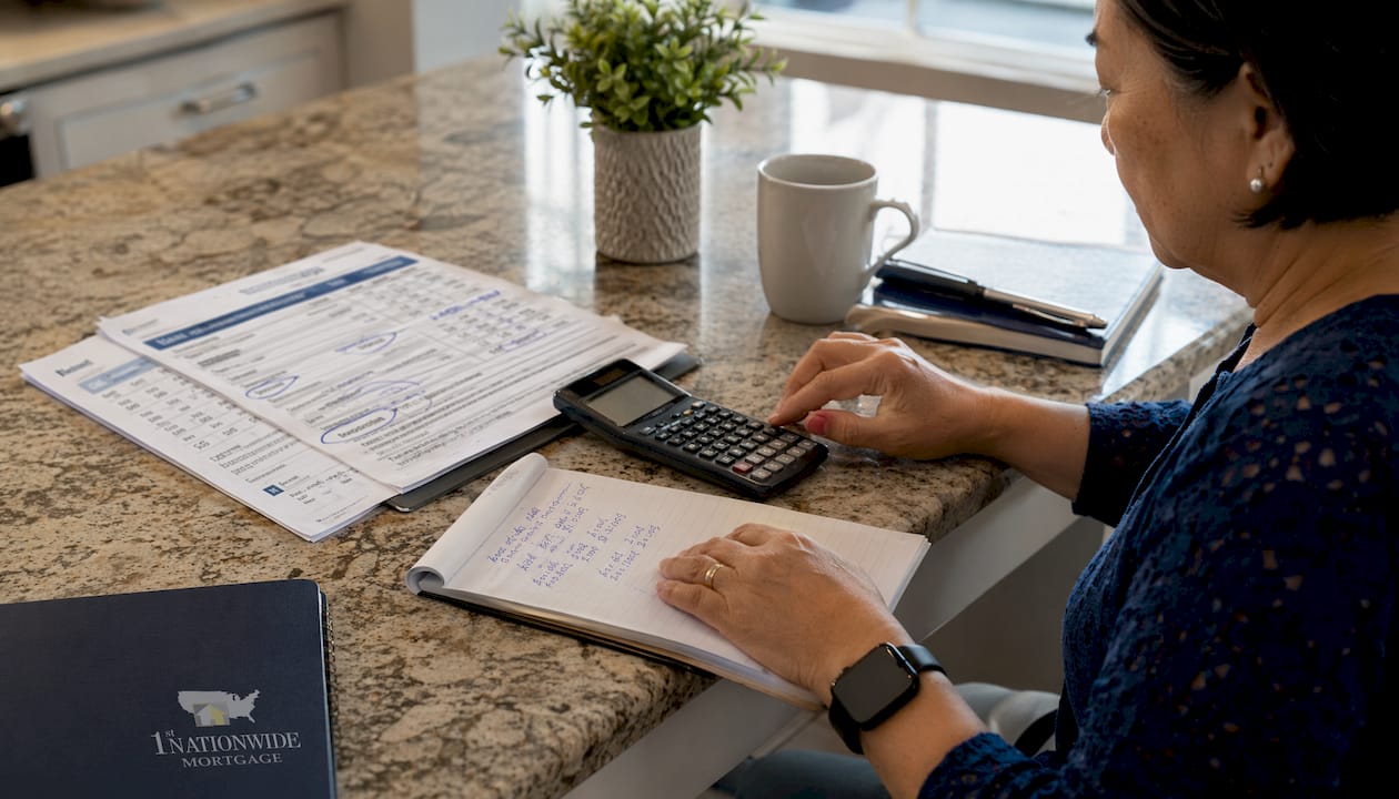 Investor calculating NONI loan numbers on desk