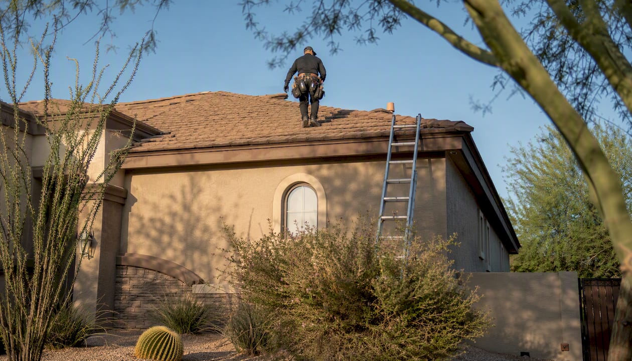 Property manager inspecting roof shingles