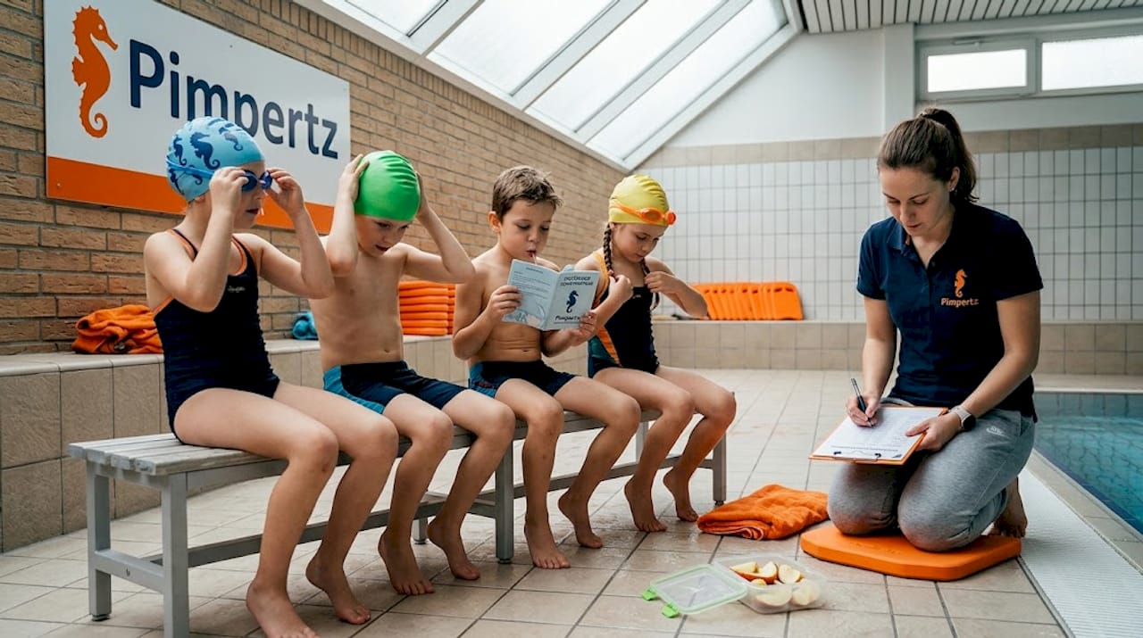 Die Kinder machen sich am Beckenrand startklar.
