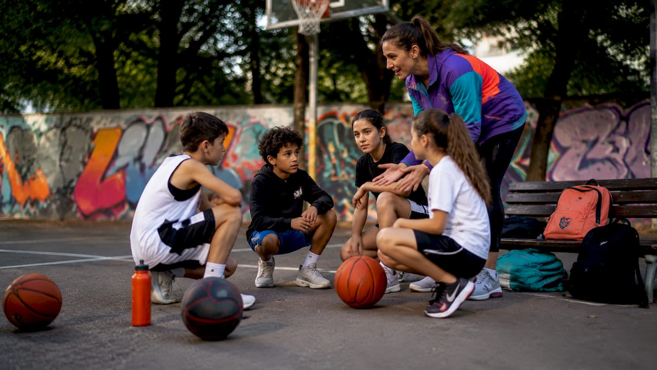Gemeinsam mit ihrem Lehrer machen sich die Schülerinnen und Schüler mit den Streetball-Regeln vertraut und probieren sie in der Praxis aus.