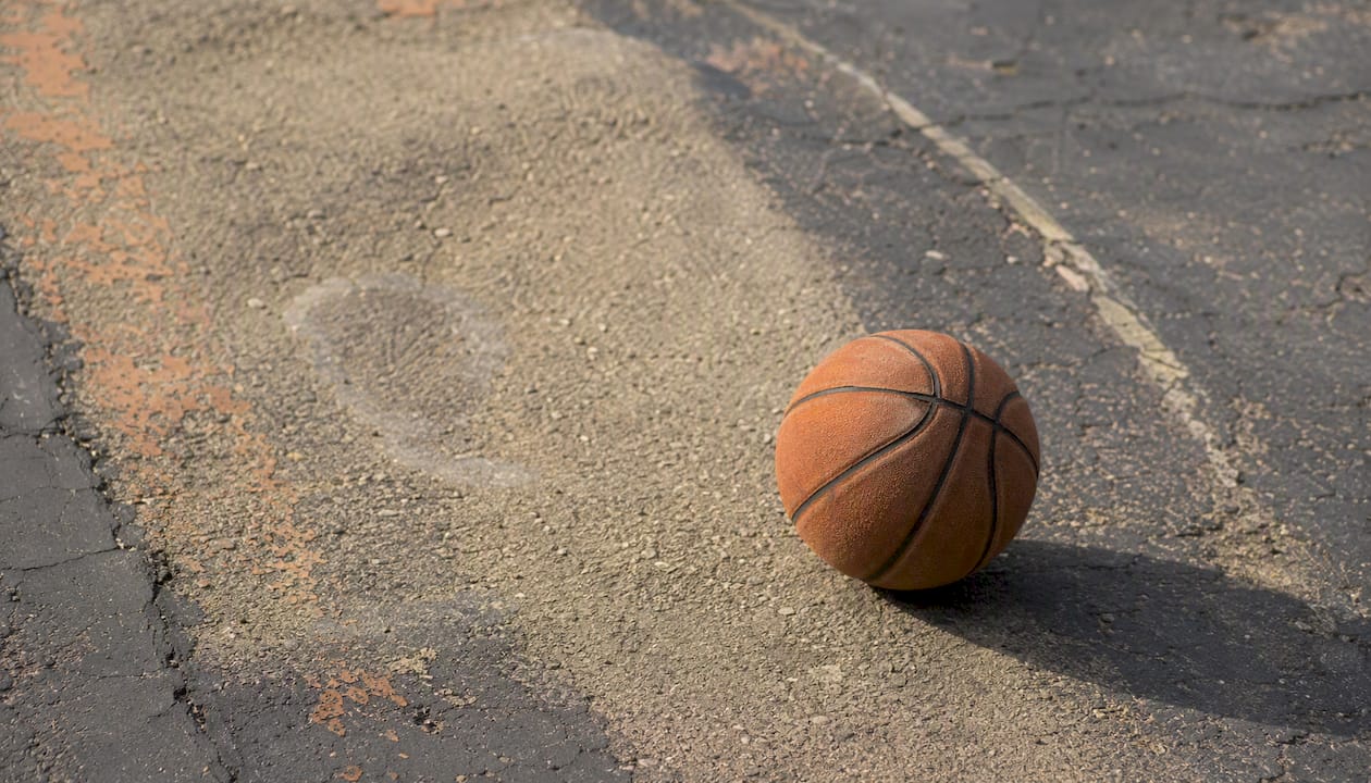 Abgenutzte Basketballfläche und rissiger Außenplatz