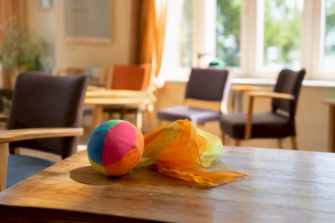 Leuchtend roter Ball und bunter Schal als visuelle Hilfsmittel