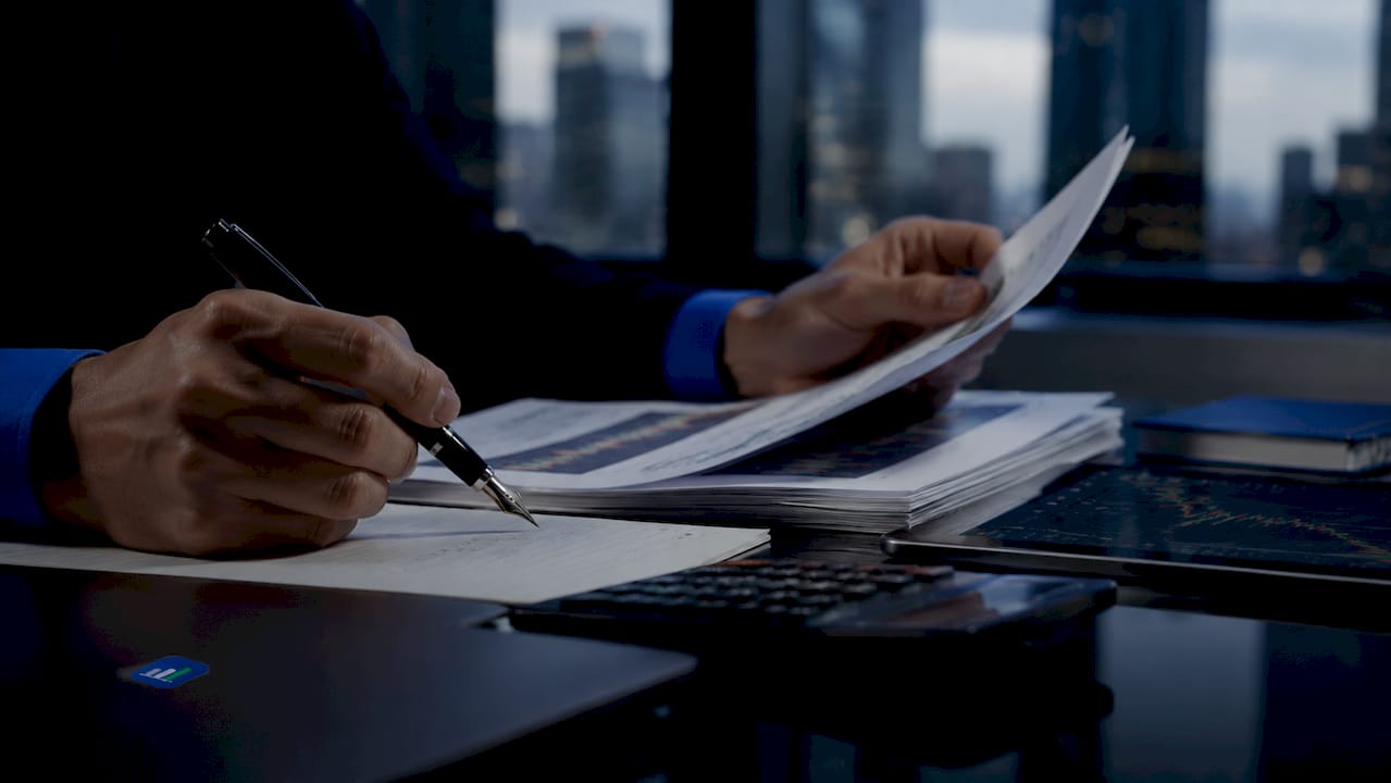 Hands making notes on trade position reports