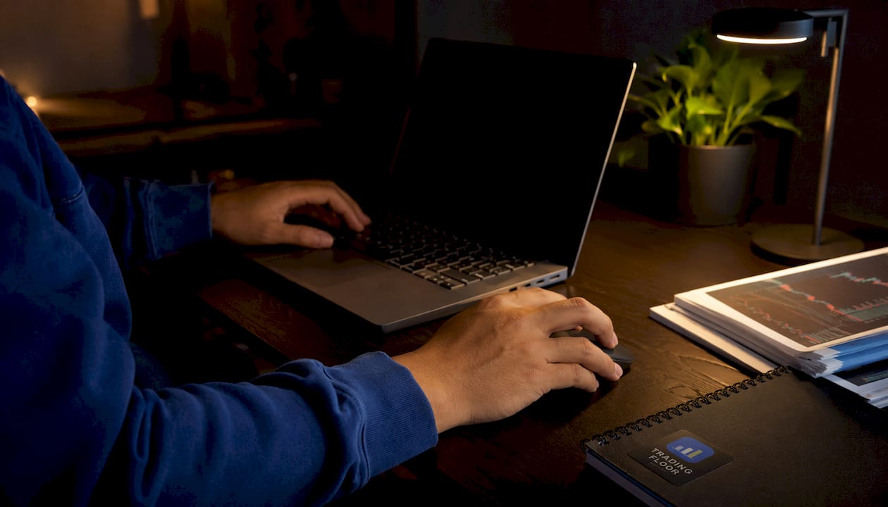 Hands interacting with laptop and mouse in bright office