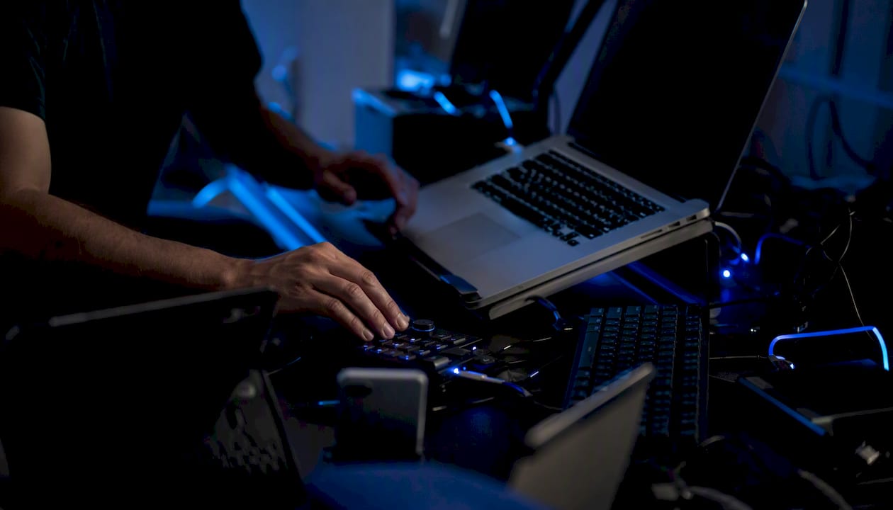 Hands connecting trading devices on dark desk