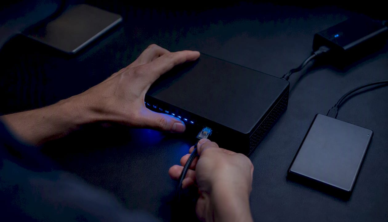 Hands connecting cable to local execution node device