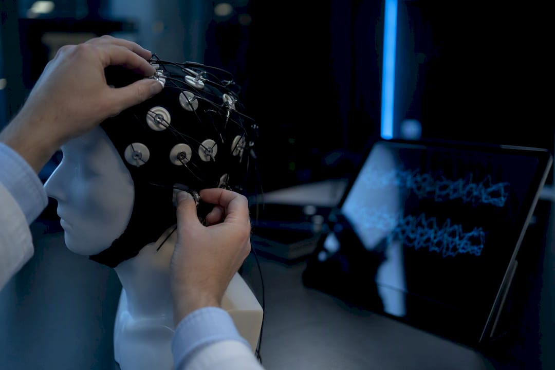 Researcher placing EEG electrodes in lab