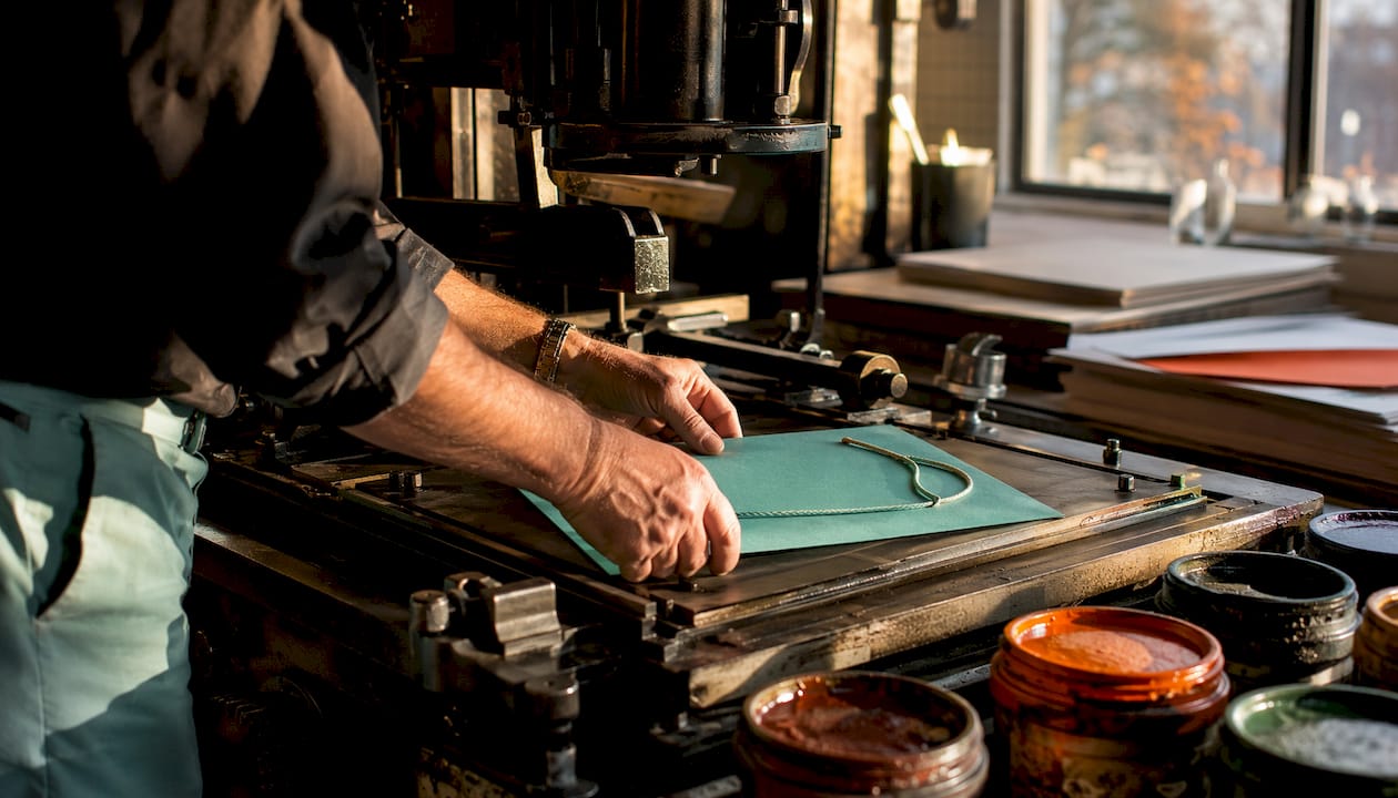 Een drukker personaliseert een cadeauzakje met de ambachtelijke techniek van letterpress.