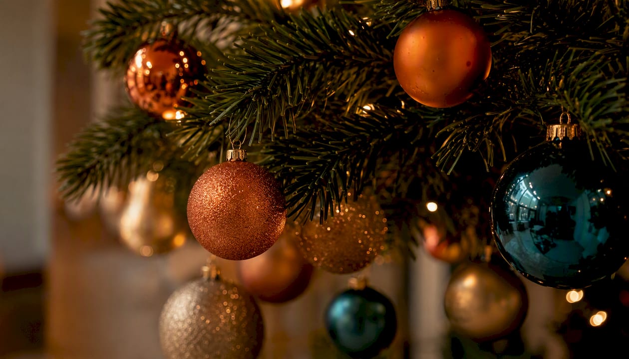 Glanzende en matte kerstballen sierlijk verspreid over een dennentak