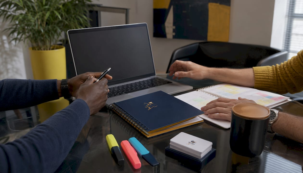 Hands comparing business platform notes in coworking space