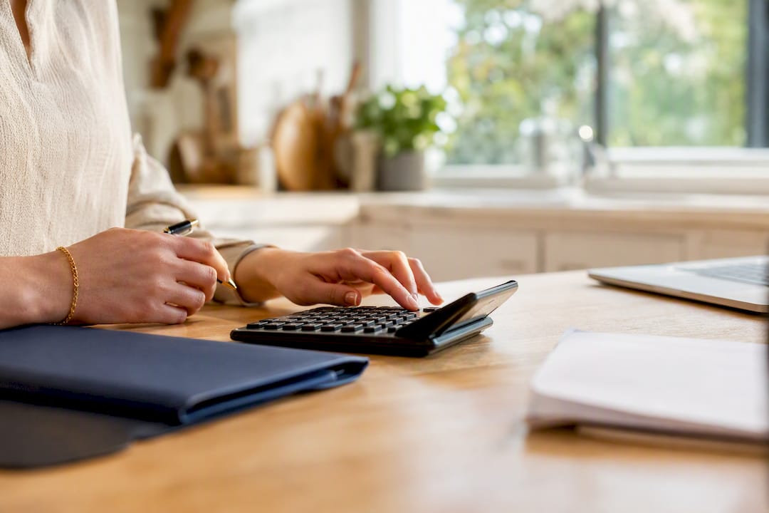 Hands using calculator for payment calculations