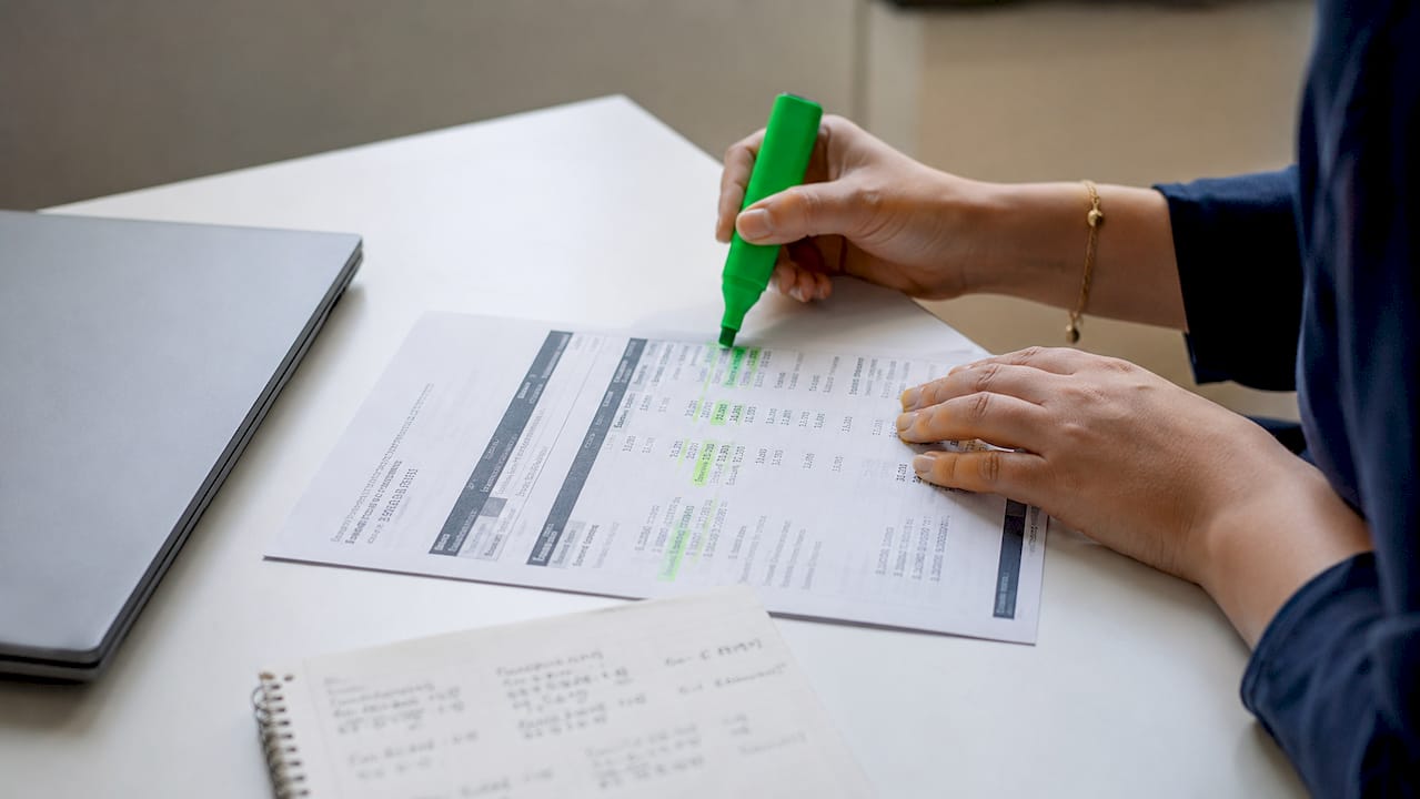 Hands reviewing credit card interest statement